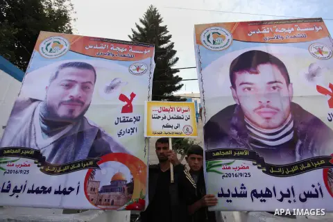 Palestinians hold banners during a protest to show solidarity with Palestinian prisoners on hunger strike in Israeli Jails, in front of the high commissioner for human rights headquarters in Gaza City, on November 22, 20...