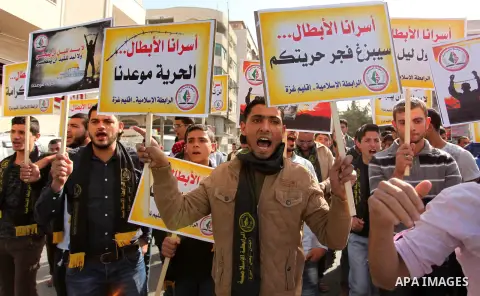 Palestinians hold banners during a protest to show solidarity with Palestinian prisoners on hunger strike in Israeli Jails, in front of the high commissioner for human rights headquarters in Gaza City, on November 22, 20...