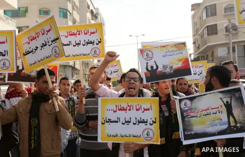 Palestinians hold banners during a protest to show solidarity with Palestinian prisoners on hunger strike in Israeli Jails, in front of the high commissioner for human rights headquarters in Gaza City, on November 22, 20...