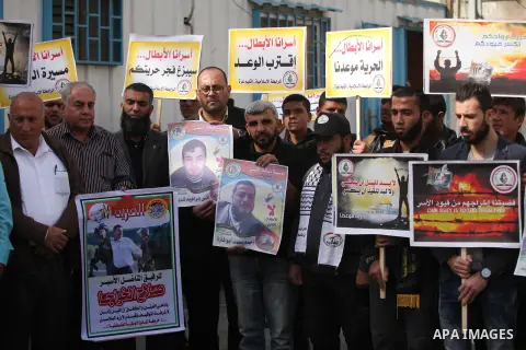 Palestinians hold banners during a protest to show solidarity with Palestinian prisoners on hunger strike in Israeli Jails, in front of the high commissioner for human rights headquarters in Gaza City, on November 22, 20...