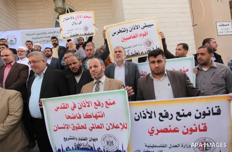 Palestinians hold banners during a protest against a controversial Israeli bill to limit the volume of calls to prayer at mosques in the occupied Jerusalem, in Gaza city on November 23, 2016. Israeli Prime Minister Benja...
