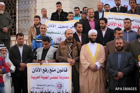 Palestinians hold banners during a protest against a controversial Israeli bill to limit the volume of calls to prayer at mosques in the occupied Jerusalem, in Gaza city on November 23, 2016. Israeli Prime Minister Benja...