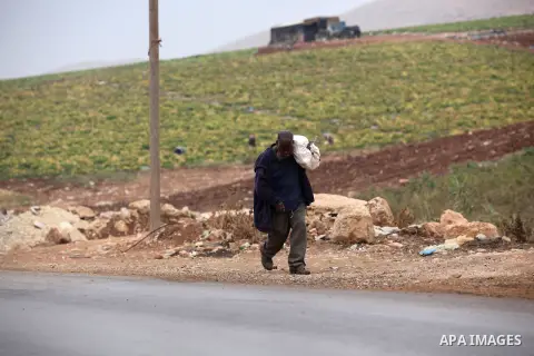 A Palestinian man carries bags of cabbage after working in a field in the West Bank village of Nassariya near Nablus November 30, 2016. Photo by Nedal Eshtayah