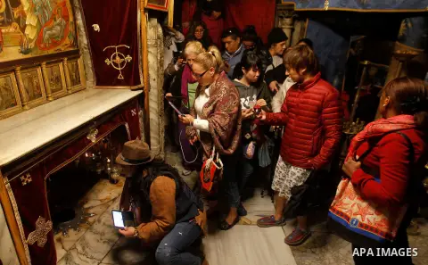 Visitors visit the holy star where Jesus Christ is believed to have been born inside the holy cave in the Church of Nativity during a Christmas tree lighting ceremony in the West Bank town of Bethlehem December 3, 2016....