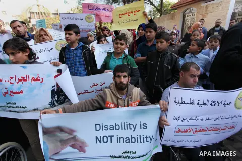 Palestinian girls with disabilities hold banners as they take parts in a rally in Gaza City demanding for the rights of people with disabilities in Gaza on December 5, 2016 Tens of thousands of Gazans are learning to liv...