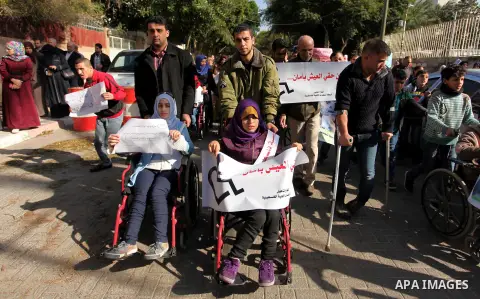 Palestinian girls with disabilities hold banners as they take parts in a rally in Gaza City demanding for the rights of people with disabilities in Gaza on December 5, 2016 Tens of thousands of Gazans are learning to liv...