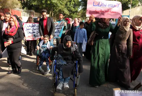 Palestinian girls with disabilities hold banners as they take parts in a rally in Gaza City demanding for the rights of people with disabilities in Gaza on December 5, 2016 Tens of thousands of Gazans are learning to liv...