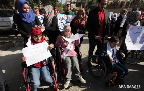 Palestinian girls with disabilities hold banners as they take parts in a rally in Gaza City demanding for the rights of people with disabilities in Gaza on December 5, 2016 Tens of thousands of Gazans are learning to liv...