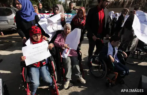 Palestinian girls with disabilities hold banners as they take parts in a rally in Gaza City demanding for the rights of people with disabilities in Gaza on December 5, 2016 Tens of thousands of Gazans are learning to liv...