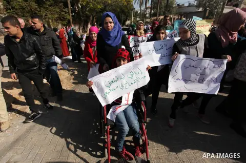 Palestinian girls with disabilities hold banners as they take parts in a rally in Gaza City demanding for the rights of people with disabilities in Gaza on December 5, 2016 Tens of thousands of Gazans are learning to liv...