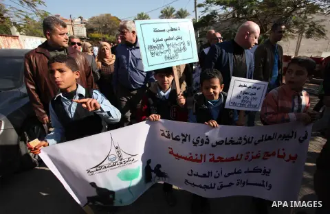 Palestinian girls with disabilities hold banners as they take parts in a rally in Gaza City demanding for the rights of people with disabilities in Gaza on December 5, 2016 Tens of thousands of Gazans are learning to liv...