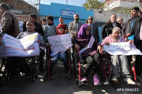 Palestinian girls with disabilities hold banners as they take parts in a rally in Gaza City demanding for the rights of people with disabilities in Gaza on December 5, 2016 Tens of thousands of Gazans are learning to liv...