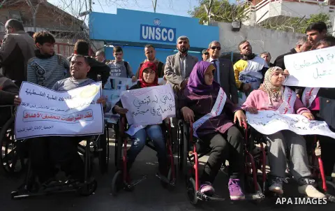 Palestinian girls with disabilities hold banners as they take parts in a rally in Gaza City demanding for the rights of people with disabilities in Gaza on December 5, 2016 Tens of thousands of Gazans are learning to liv...