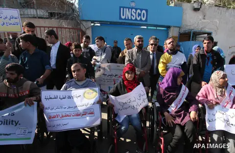 Palestinian girls with disabilities hold banners as they take parts in a rally in Gaza City demanding for the rights of people with disabilities in Gaza on December 5, 2016 Tens of thousands of Gazans are learning to liv...