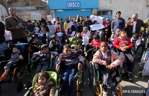 Palestinian girls with disabilities hold banners as they take parts in a rally in Gaza City demanding for the rights of people with disabilities in Gaza on December 5, 2016 Tens of thousands of Gazans are learning to liv...