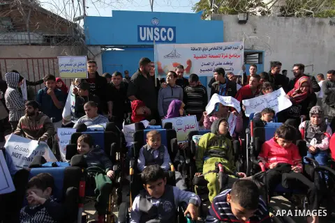 Palestinian girls with disabilities hold banners as they take parts in a rally in Gaza City demanding for the rights of people with disabilities in Gaza on December 5, 2016 Tens of thousands of Gazans are learning to liv...