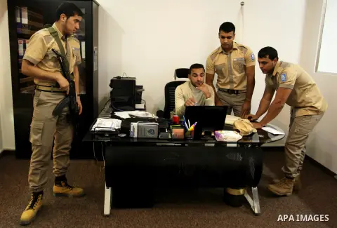 Palestinian Akram Al-Balawi, director of Castle Security company, speaks with a private security guard in the company's office in Gaza City on December 08, 2016. Photo by Ashraf Amra