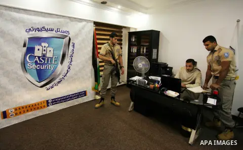 Palestinian Akram Al-Balawi, director of Castle Security company, speaks with a private security guard in the company's office in Gaza City on December 08, 2016. Photo by Ashraf Amra
