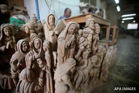 A Palestinian carpenter carves a wooden effigies of the the Holy Family at a workshop in the West Bank town of Bethlehem, on December 13, 2016. The traditional birthplace of Jesus Christ prepares to celebrate Christmas l...