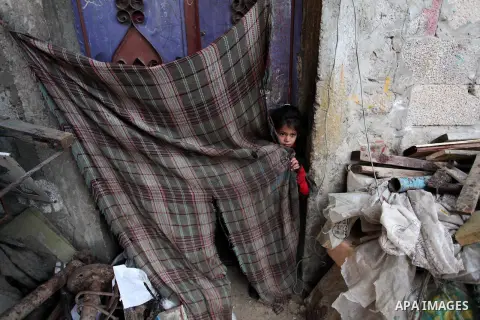 A Palestinian girl plays outside her family's shanty during the winter storm in Khan Younis, in the southern Gaza Strip on December 14, 2016. Photo by Ashraf Amra