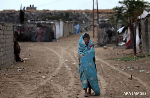 A Palestinian boy walks outside his family's shanty during the winter storm in Khan Younis, in the southern Gaza Strip on December 14, 2016. Photo by Ashraf Amra