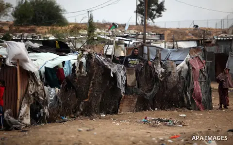 A Palestinian man looks out of his family's tent during the winter storm in Khan Younis, in the southern Gaza Strip on December 14, 2016. Photo by Ashraf Amra