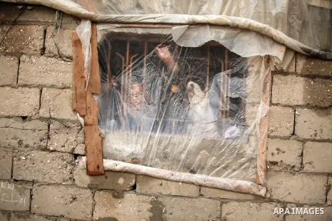 A Palestinian boy looks through a Window of nylon during the winter storm in Khan Younis, in the southern Gaza Strip on December 14, 2016. Photo by Ashraf Amra