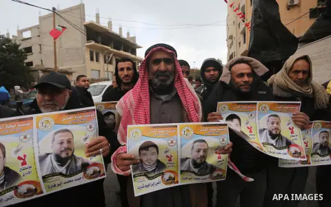 Palestinian hold banners during a protest to show solidarity with prisoner on hunger strike, in front of Red Cross, in Gaza city, on December 14, 2016. Photo by Mohammed Asad
