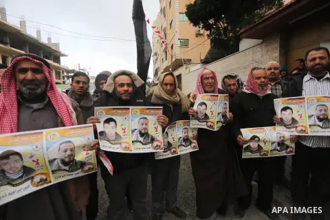Palestinian hold banners during a protest to show solidarity with prisoner on hunger strike, in front of Red Cross, in Gaza city, on December 14, 2016. Photo by Mohammed Asad