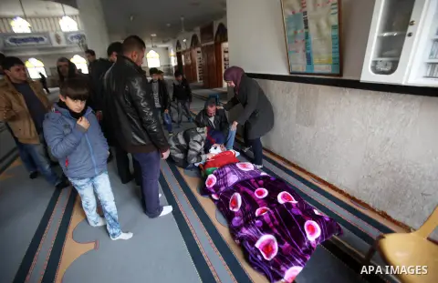 A man reads the Koran near the body of Palestinian Rahiq Birawi, who according to the Israeli police was shot dead after she had advanced towards them with a knife in her hand at a checkpoint last October, during her fun...