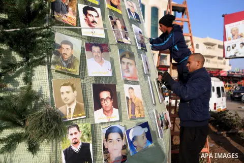 Palestinian youths use pictures of Palestinian martyrs to decorate a Christmas tree, in the West Bank town of al-Azariya, east of Jerusalem, on December 22, 2016. Photo by Shadi Hatem