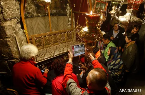 Africans Christian pilgrims look to a 14-point silver star on the marble floor of the Grotto in the Church of the Nativity, believed to be the birthplace of Jesus Christ, in the West Bank city of Bethlehem on December 22...
