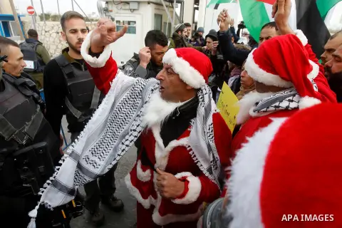 A Palestinian protester dressed up as Santa Claus argues with Israeli border guard during clashes at a demonstration next to a section of Israel's separation wall in the biblical town of Bethlehem, in the occupied West B...