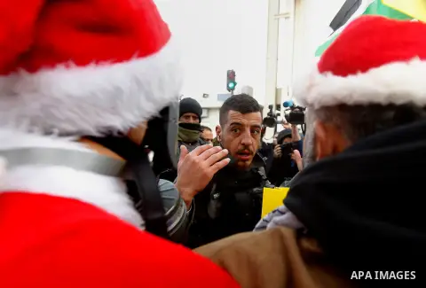 A Palestinian protester dressed up as Santa Claus argues with Israeli border guard during clashes at a demonstration next to a section of Israel's separation wall in the biblical town of Bethlehem, in the occupied West B...
