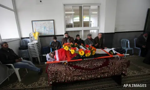 Mourners gather around the body of Palestinian Jihad Khalil, who according to the Israeli police was shot and killed by an Israeli security guard after Khalil tried to stab him last November, during his funeral after Isr...