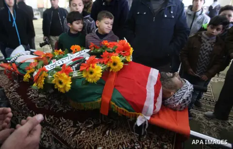 Mourners gather around the body of Palestinian Jihad Khalil, who according to the Israeli police was shot and killed by an Israeli security guard after Khalil tried to stab him last November, during his funeral after Isr...