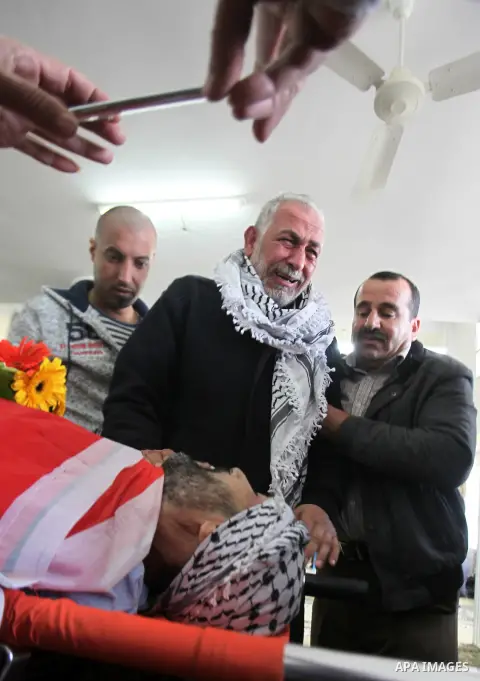 Mourners gather around the body of Palestinian Jihad Khalil, who according to the Israeli police was shot and killed by an Israeli security guard after Khalil tried to stab him last November, during his funeral after Isr...