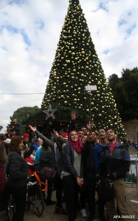 Palestinians attend a Christian scouts performance at the Manger Square outside the Church of the Nativity during Christmas celebrations in the city of Bethlehem in the Israeli-occupied West Bank, on December 24, 2016. P...