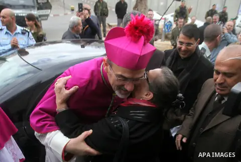 The Latin Patriarch of Jerusalem Pierbattista Pizzaballa is greeted upon his arrival through an Israeli checkpoint to attend Christmas celebrations, in the West Bank city of Bethlehem December 24, 2016. Photo by Wisam Ha...