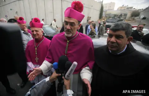 The Latin Patriarch of Jerusalem Pierbattista Pizzaballa is greeted upon his arrival through an Israeli checkpoint to attend Christmas celebrations, in the West Bank city of Bethlehem December 24, 2016. Photo by Wisam Ha...