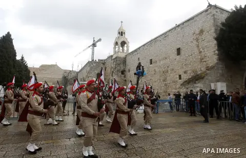 Palestinian Christian scouts perform at the Manger Square outside the Church of the Nativity as people gather for Christmas celebrations in the city of Bethlehem in the Israeli-occupied West Bank, on December 24, 2016. P...