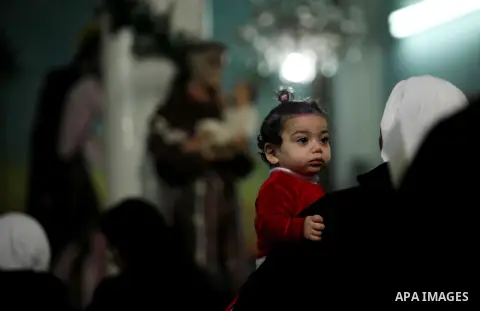 Palestinian Christians attend Christmas mass at Der Latin church, in Gaza City on December 25, 2016. Photo by Ashraf Amra