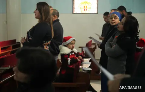 Palestinian Christians attend Christmas mass at Der Latin church, in Gaza City on December 25, 2016. Photo by Ashraf Amra