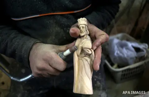 A Palestinian carpenter carves a wooden effigies of the the Holy Family at a workshop in the West Bank town of Bethlehem, on December 26, 2016. The traditional birthplace of Jesus Christ prepares to celebrate Christmas....