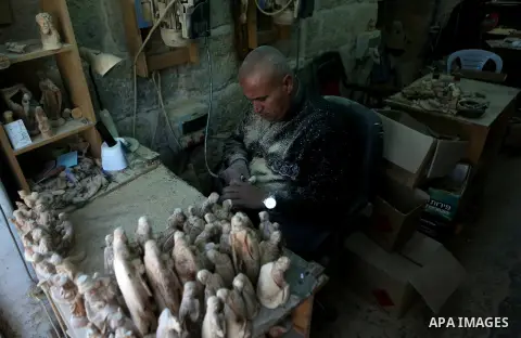 A Palestinian carpenter carves a wooden effigies of the the Holy Family at a workshop in the West Bank town of Bethlehem, on December 26, 2016. The traditional birthplace of Jesus Christ prepares to celebrate Christmas....