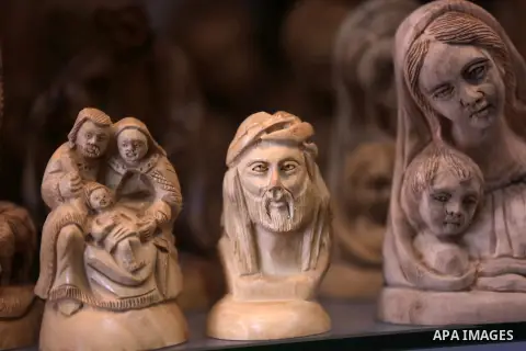 A woden effigies of the the Holy Family are seen at a workshop in the West Bank town of Bethlehem, on December 26, 2016. The traditional birthplace of Jesus Christ prepares to celebrate Christmas. Photo by Shadi Hatem