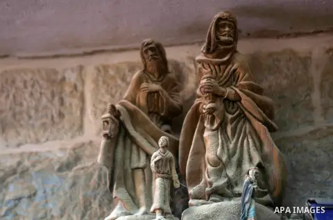 A woden effigies of the the Holy Family are seen at a workshop in the West Bank town of Bethlehem, on December 26, 2016. The traditional birthplace of Jesus Christ prepares to celebrate Christmas. Photo by Shadi Hatem