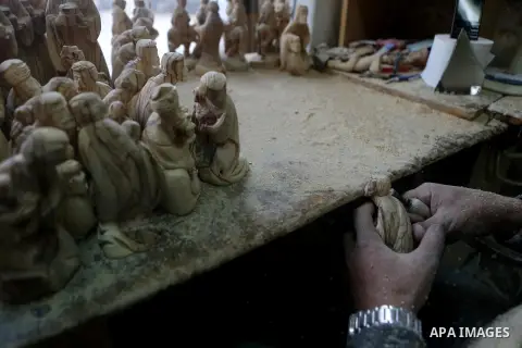 A Palestinian carpenter carves a wooden effigies of the the Holy Family at a workshop in the West Bank town of Bethlehem, on December 26, 2016. The traditional birthplace of Jesus Christ prepares to celebrate Christmas....