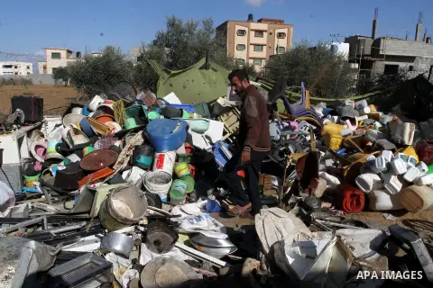 Palestinian Ziad Abu Jamea, collects his belongings outside his house which was destroyed during the 50-day war between Israel and Hamas militants in the summer of 2014, on in Khan Younis in the southern Gaza Strip Decem...