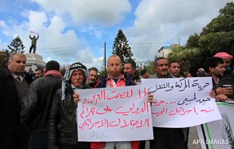 Palestinian workers shout slogans during a protest against the siege of Gaza, in Gaza City, on December 27, 2016. Photo by Ashraf Amra